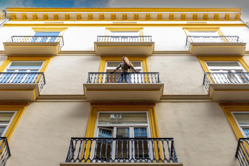 Una mujer parada en el balcón de un edificio. en Camila Hostel Valencia, en Valencia