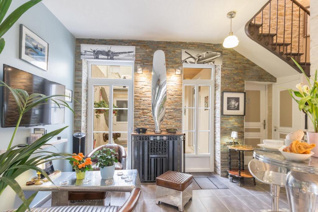 a living room with a brick wall and a fireplace at DDay Aviators in Arromanches-les-Bains