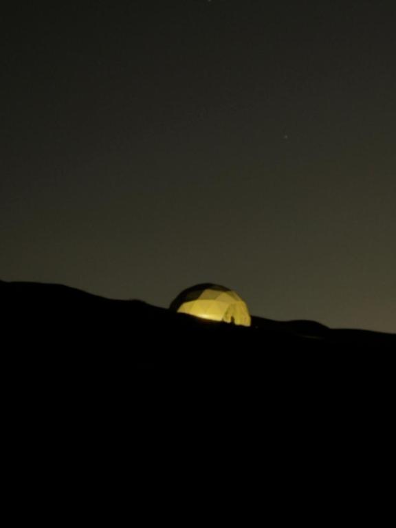 an object sitting on top of a hill at night at The mirage dome in Bidiyah
