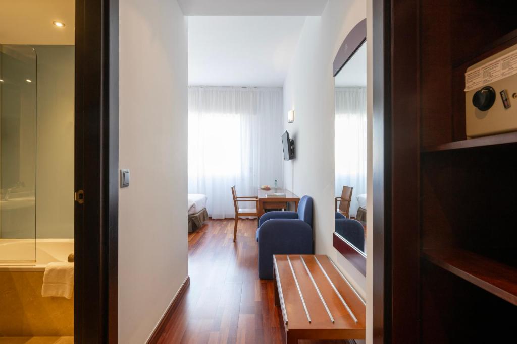 een woonkamer met een blauwe bank en een tafel bij Hotel Maroa Vigo in Vigo