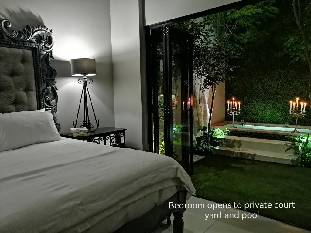 a bedroom with a bed and a garden with a tub at Another World - Montagu in Montagu