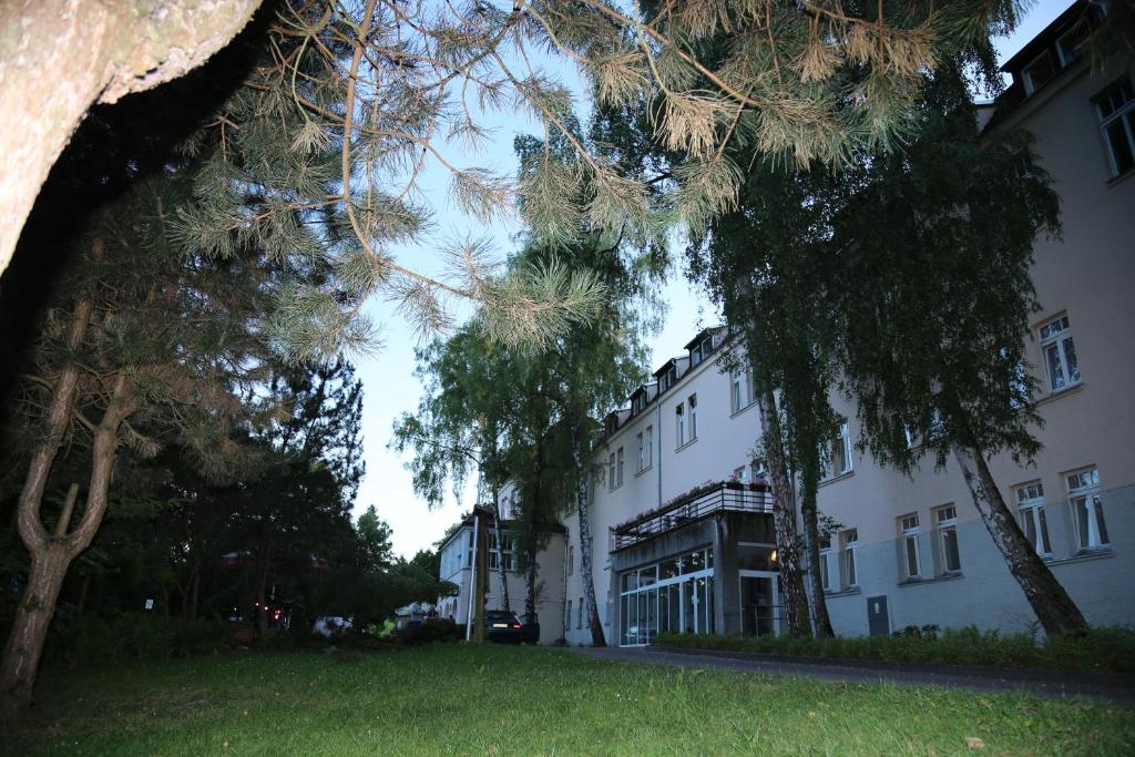 a large white building with trees in front of it at Sanatorium Borkowo in Połczyn-Zdrój
