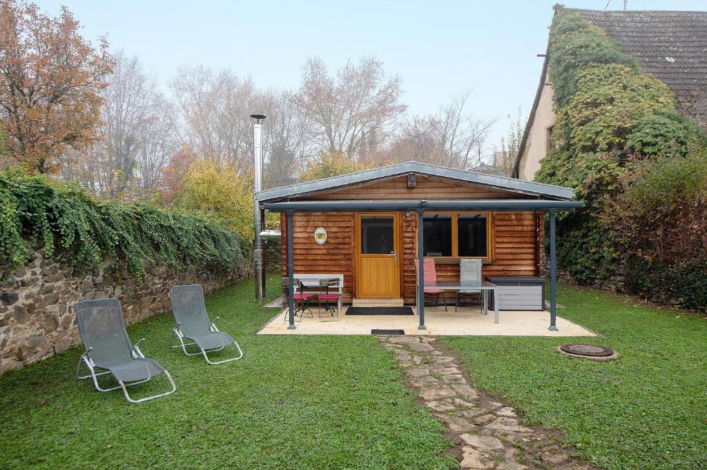 Una cabaña con una mesa y sillas en un patio. en Ferienhaus Weichart, en Sulzburg