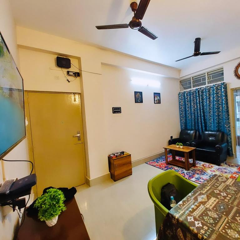 a living room with a ceiling fan and a table at The Mishing Room in Guwahati