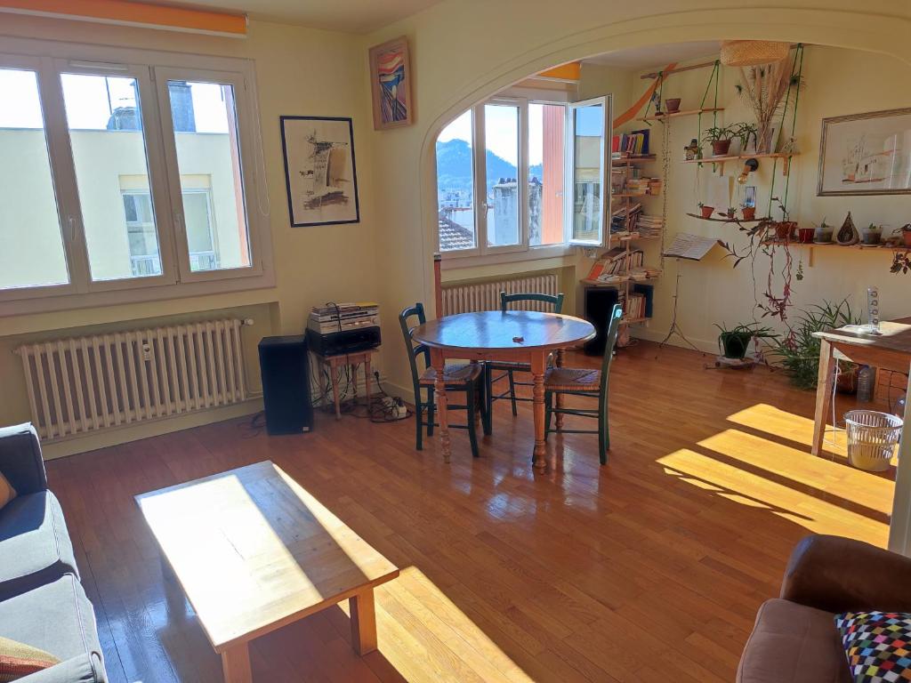 a living room with a table and chairs at Appartement plein centre in Saint-Étienne