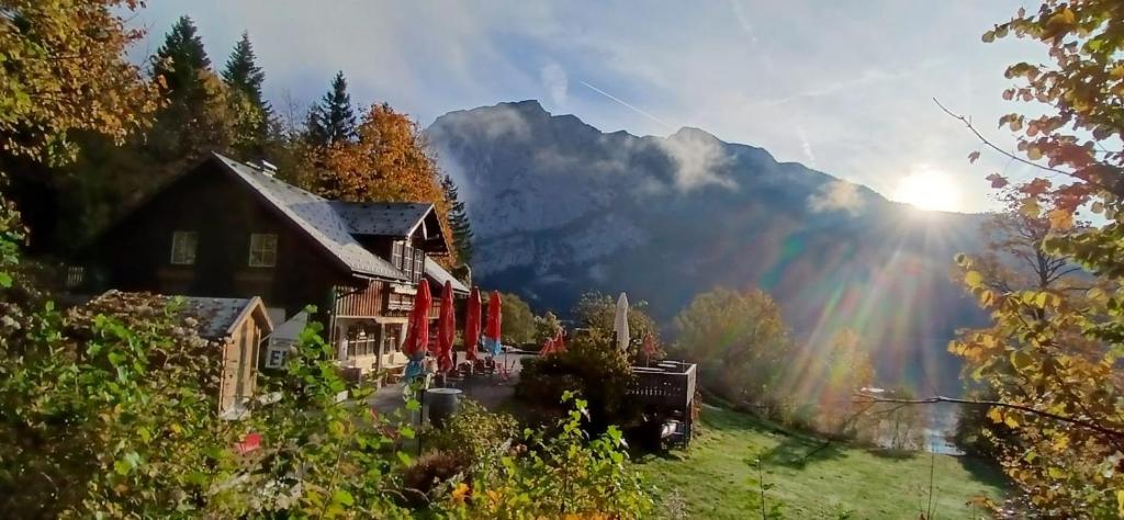 a house in the mountains with a rainbow in the sky at Ferienwohnung Kahlseneck in Fischerndorf