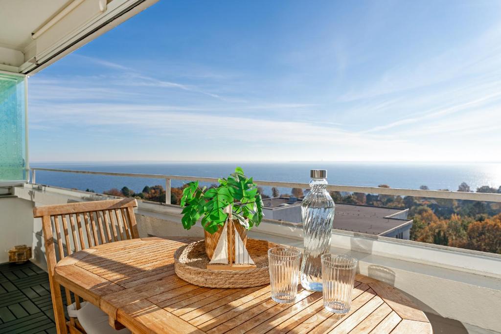 uma mesa de madeira numa varanda com vista para o oceano em Panoramic Loft mit Meerblick em Sierksdorf