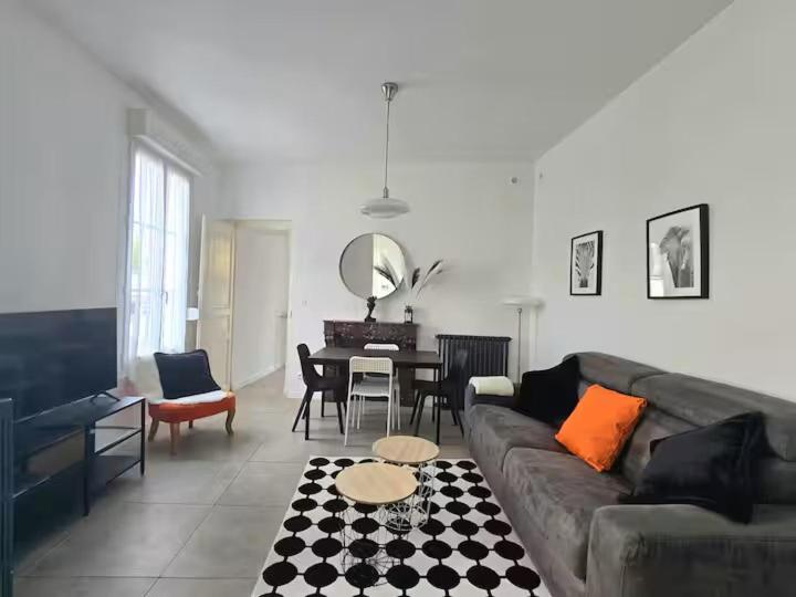 een woonkamer met een bank en een tafel bij Le B & W in Le Mans