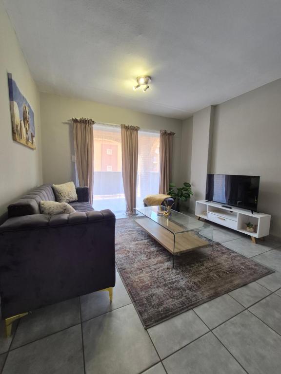 a living room with a couch and a tv at Mlangeni's Rest in Centurion