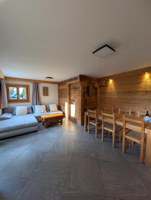 Una sala de estar con un sofá y paredes de madera. en Appt de charme dans chalet - cosy & nature, en Villars-sur-Ollon