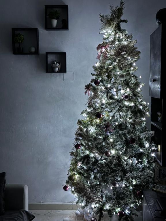 a christmas tree with decorations in a living room at Sun House in Palermo