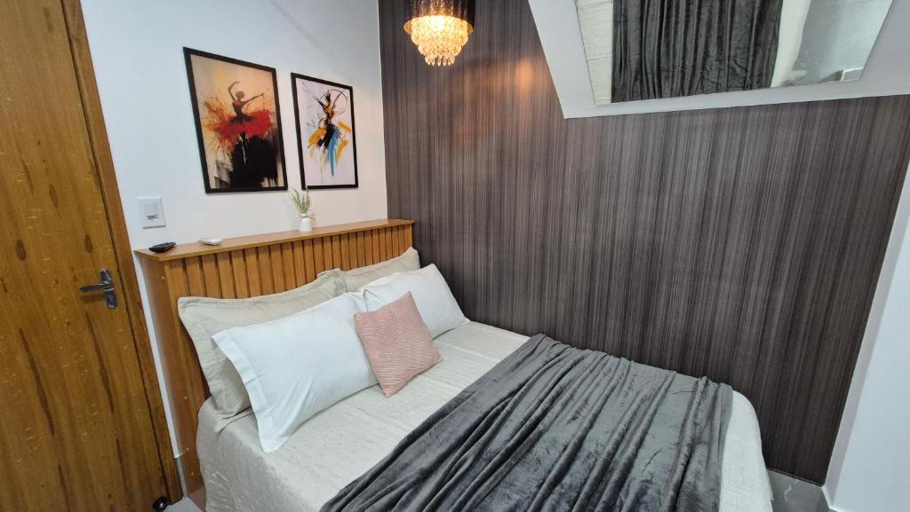 a small bedroom with a bed with a wooden headboard at Stúdio 7 climatizado, centro-terreo-privativo in Domingos Martins