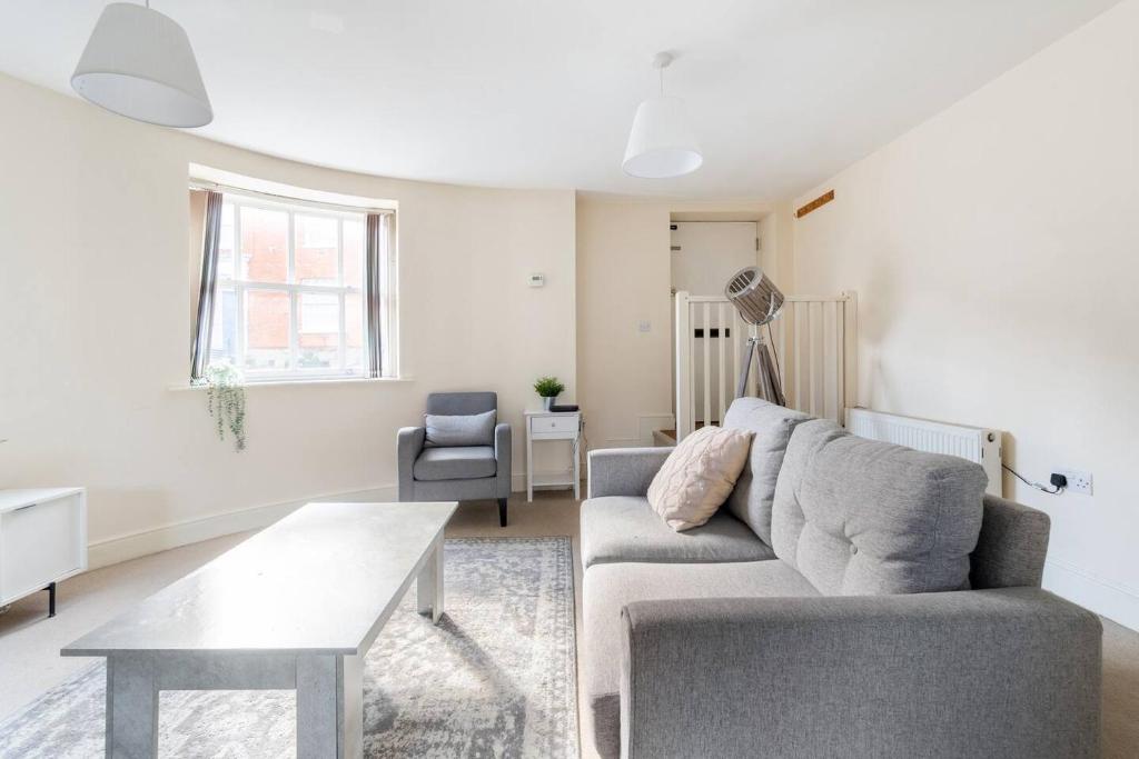 ein Wohnzimmer mit Sofa und Tisch in der Unterkunft Cosy Cottage-Like Apartments Axminster in Axminster