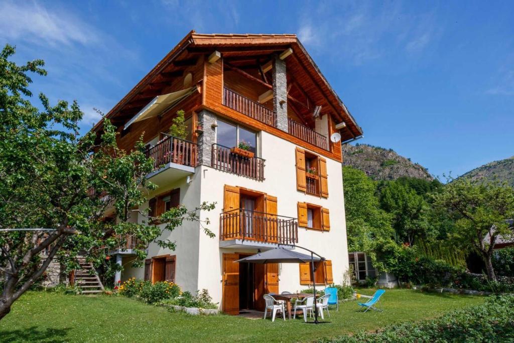 une maison avec un balcon, une table et des chaises dans l'établissement Les jasmins, à Saint-Étienne-de-Tinée