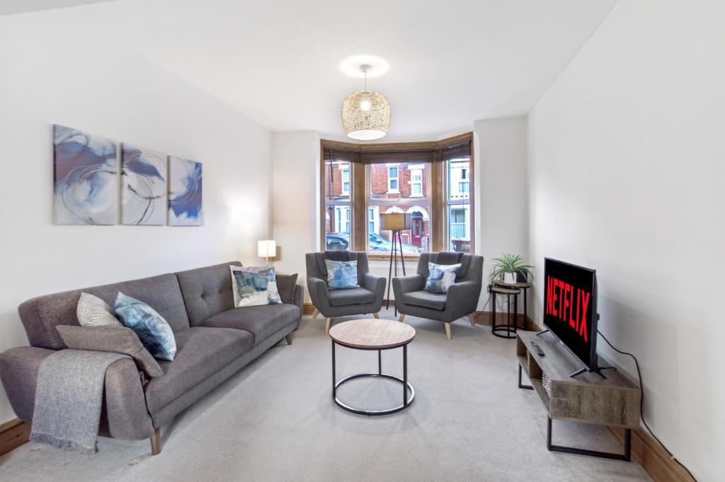 ベッドフォードにあるLuxeVille I Serene 3BR Apartment with Private Courtyard I LongTerm RatesI ParkingI WiFiのソファとテーブルのあるリビングルーム