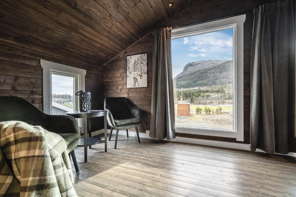 ein Schlafzimmer mit großem Fenster und Tisch und Stühlen in der Unterkunft Unique 'Stabbur' in Hemsedal, view to skislopes in Kyrkjebøen