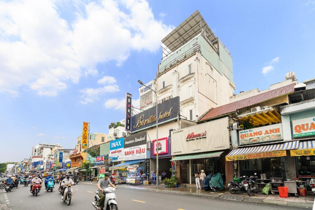a group of people riding motorcycles down a city street at Collection O District 10 - Bonita Grand Hotel in Ho Chi Minh City