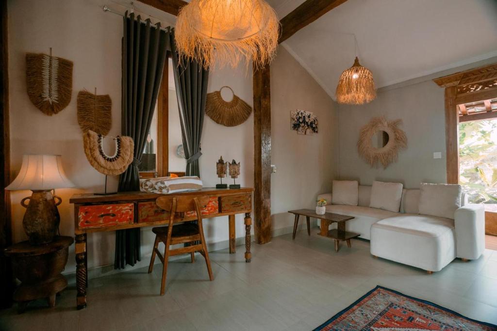 ein Wohnzimmer mit einer weißen Couch und einem Tisch in der Unterkunft Villa Soluna Lovina in Lovina