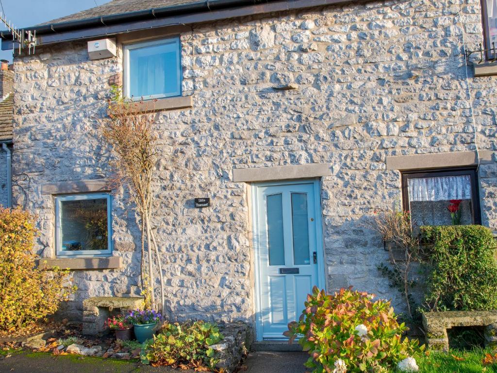 a stone house with a blue door at Little Thornsett in Buxton