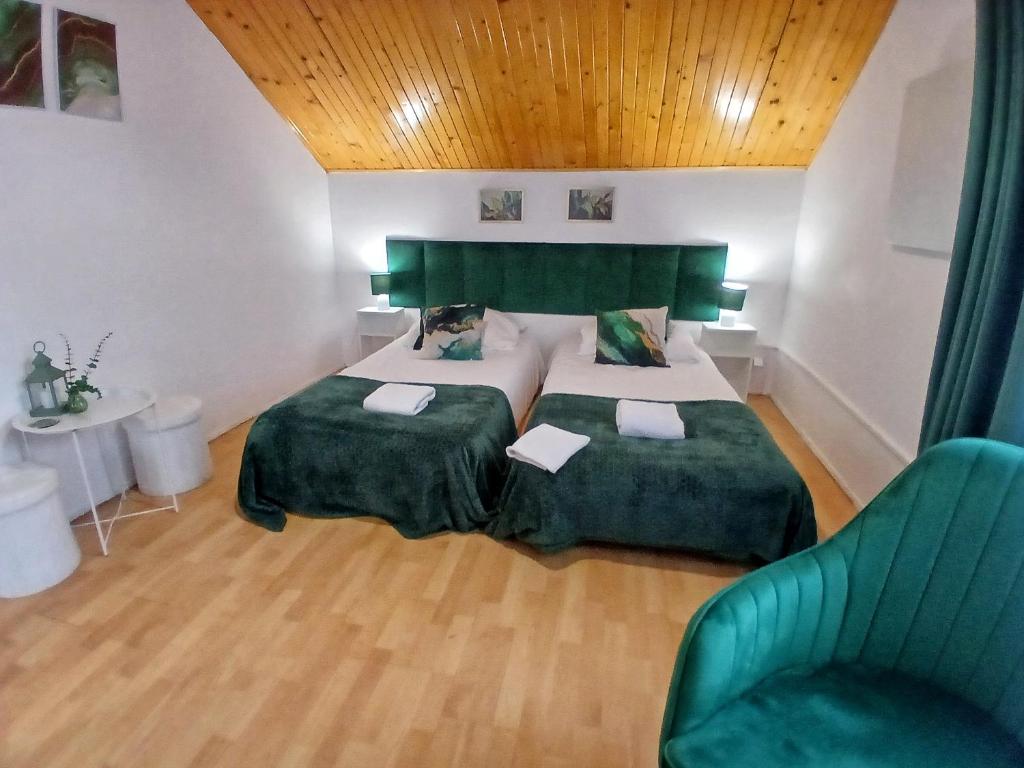 a bedroom with two beds and a green chair at KRK stop in Cholerzyn