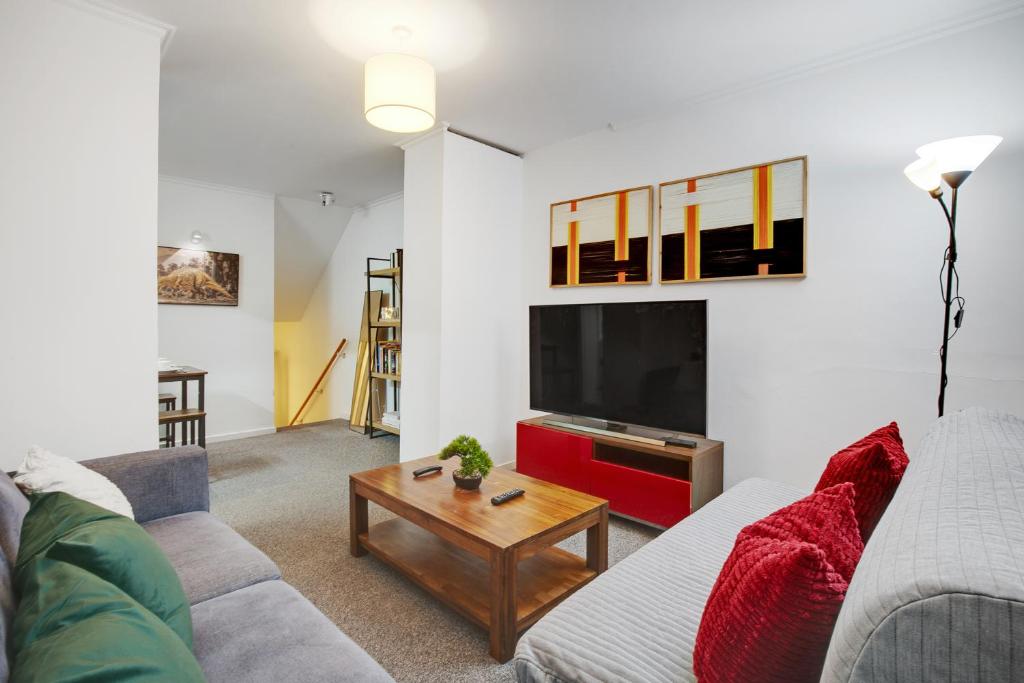 un soggiorno con un divano e una TV di Central London 2-Bed Flat - 6min to Victoria Station a Londra