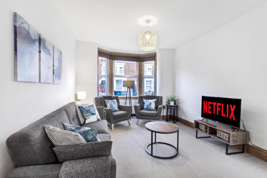 a living room with a couch and a tv at Home Away I 3BR Comfort Suite I Private Courtyard I Super Fast Wi-Fi I Free Parking in Bedford