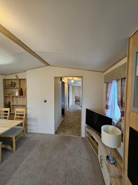 a living room with a table and a television at KMH Caravans at Flamingo Land in Kirby Misperton