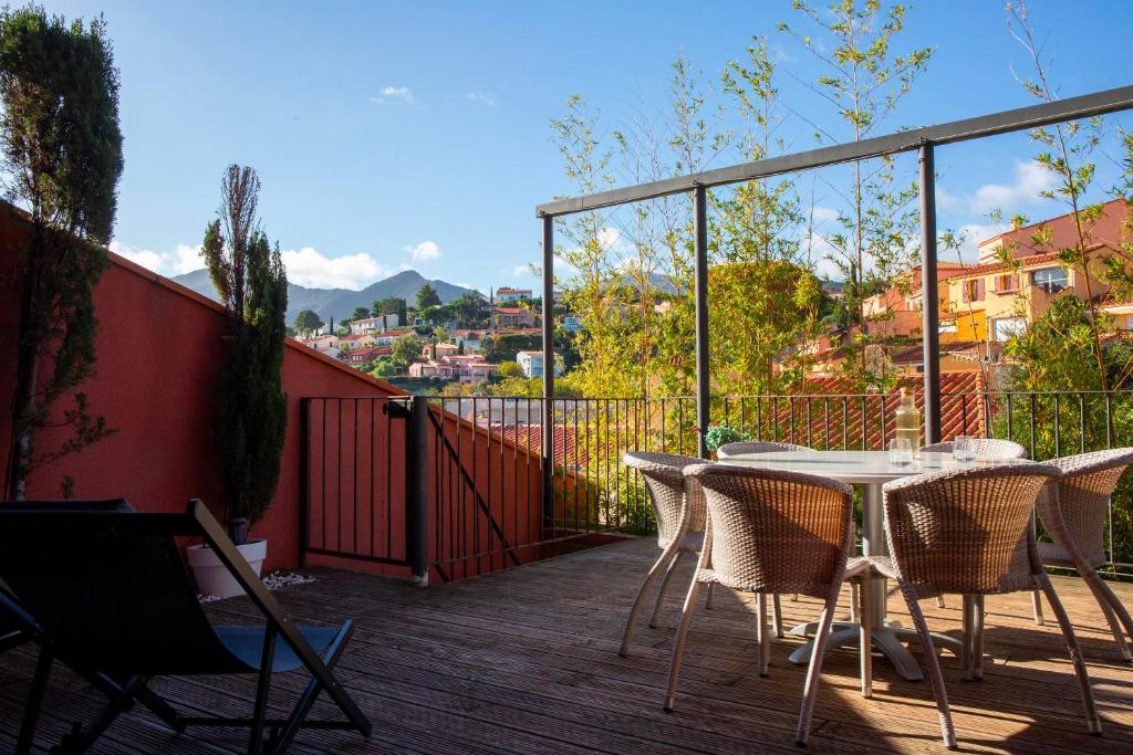 a patio with a table and chairs on a deck at Appartements Hôtel & Spa Le Madeloc in Collioure