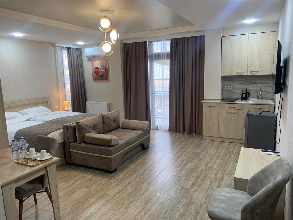 Una gran habitación de hotel con una cama y un sofá. en Hotel K124, en Kutaisi