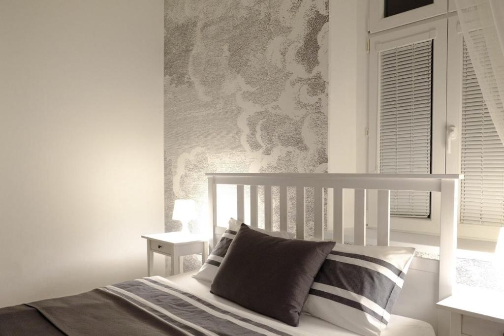 a white bedroom with a bed and a window at Ubytování Javorka in Česká Třebová