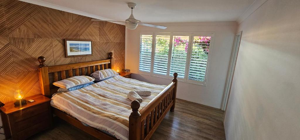 a bedroom with a large wooden bed with a window at Beach side studio Quindalup in Quindalup