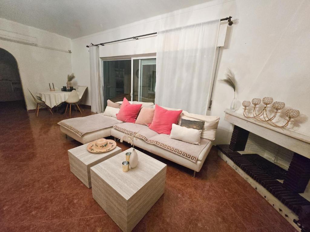 een woonkamer met een bank en een open haard bij Dias de sol in Fuzeta