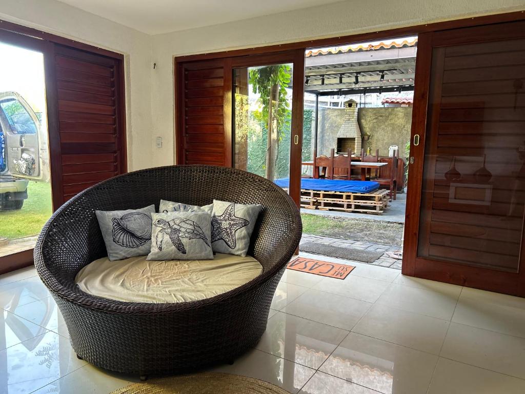 einen Korbstuhl mit Kissen im Wohnzimmer in der Unterkunft Casa da Cabana Guajiru in Trairi