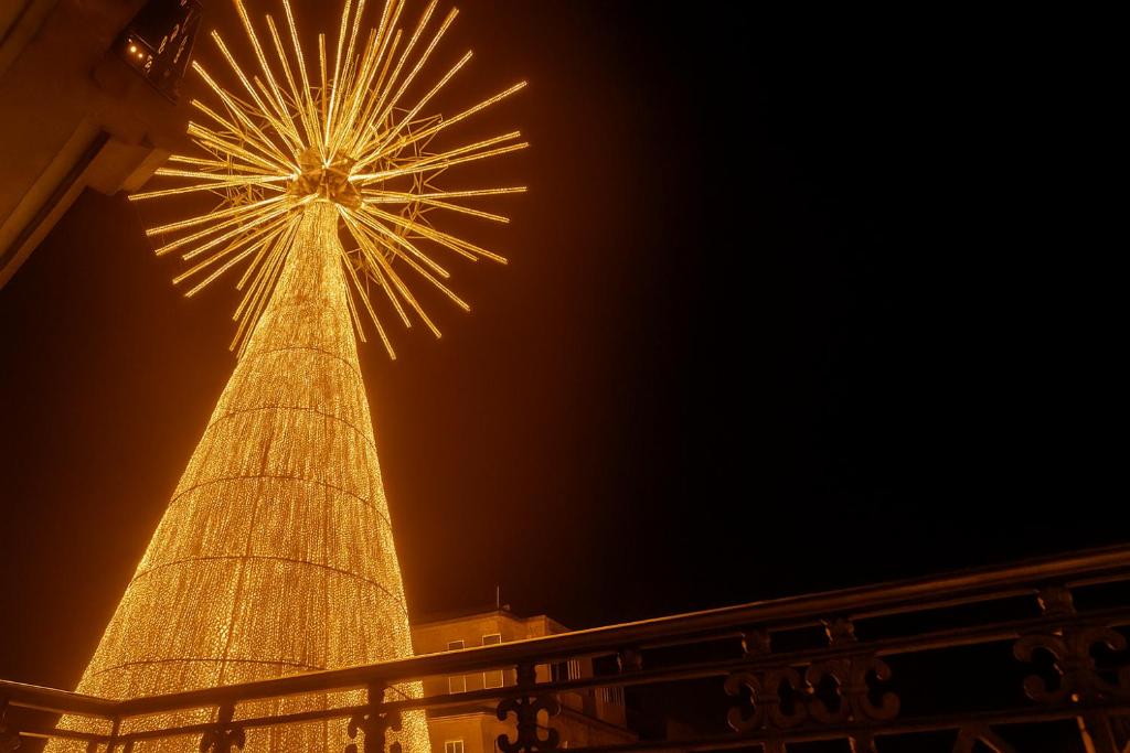 una torre alta con luces encendidas por la noche en PUERTA DEL SOL - Vigo Centro, en Vigo