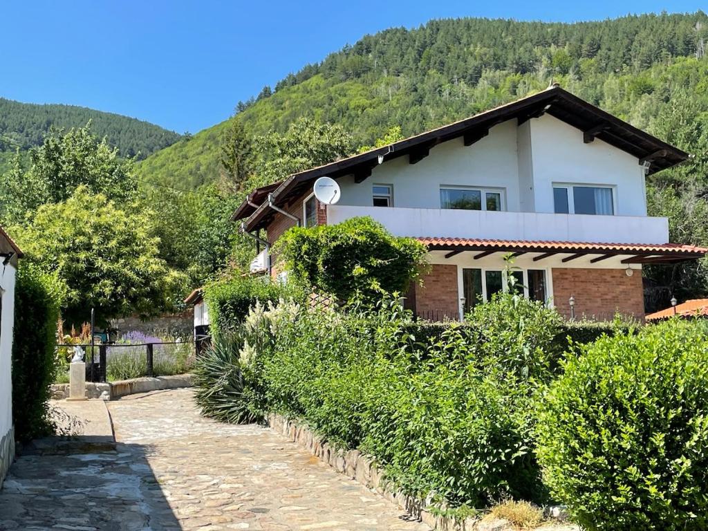 a house with a mountain in the background at Райска тишина in Zlatitsa
