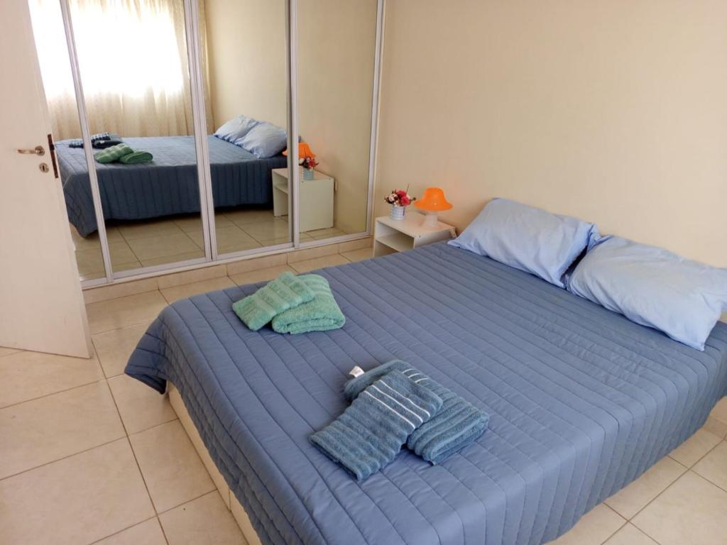 a bedroom with a blue bed with towels on it at Apart Azul y Verde cochera gratis in Necochea
