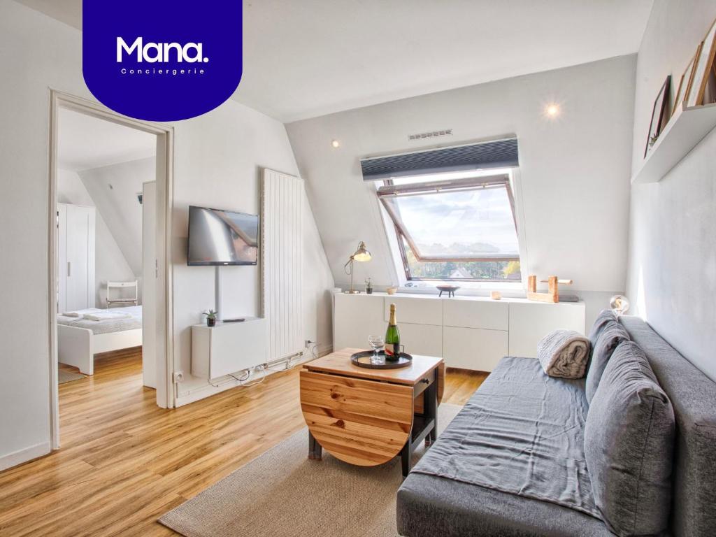 a living room with a couch and a table at Appartement classé 2 étoiles à Cabourg - Proche plage et centre-ville in Cabourg