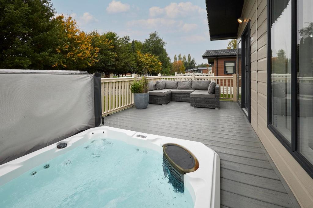 a hot tub on the deck of a house at Primrose Lodge with Hot Tub in York