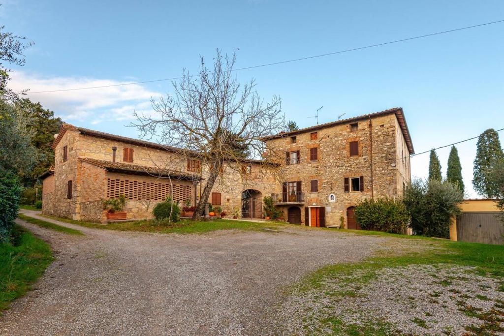 an old stone building with a road in front of it at Il Tinaio di Mary in Cetona