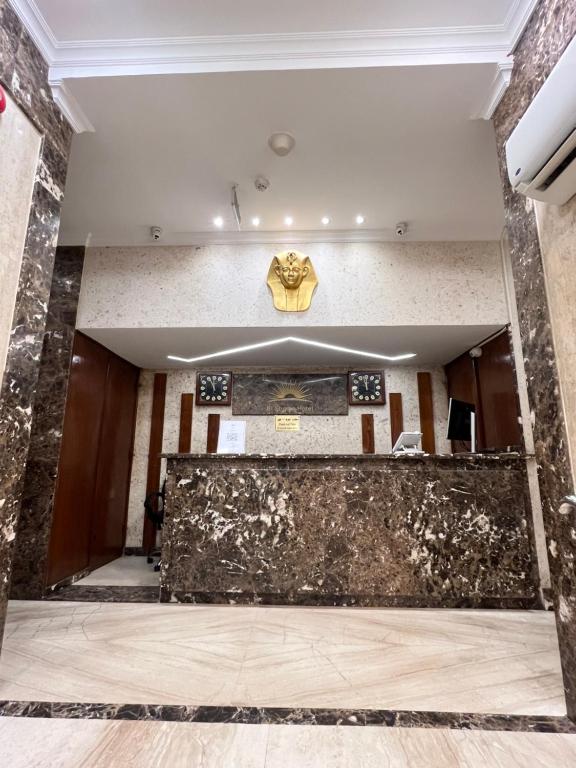 die Lobby eines Gebäudes mit einer großen Steinmauer in der Unterkunft City Sun Cairo Hotel in Kairo