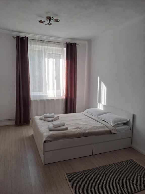 a white bedroom with a bed with a window at Studio One in Făgăraş