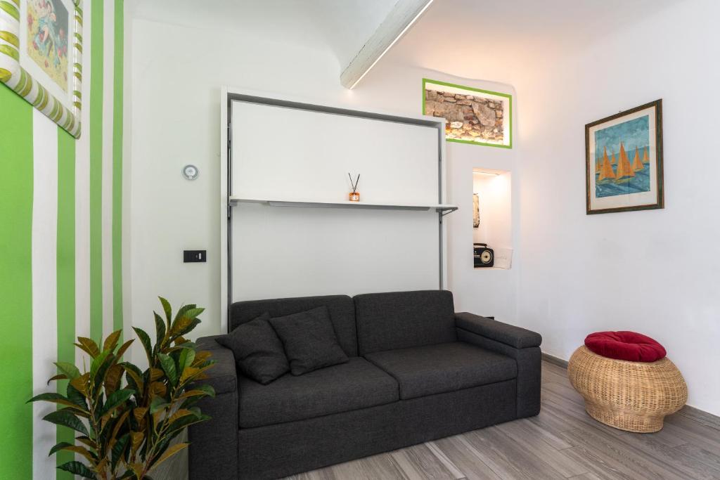 een woonkamer met een bank in een kamer bij La Casetta Verde con Vista Mare - Nel cuore del Parasio e delle Logge di Santa Chiara in Imperia