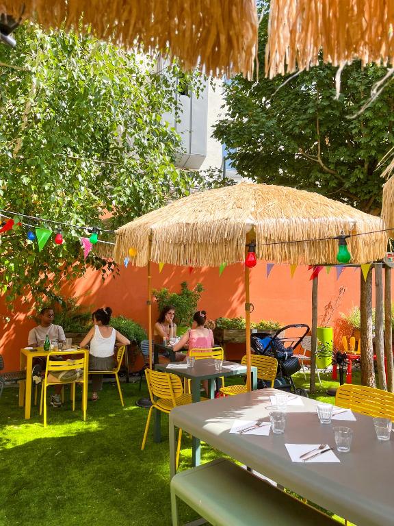 a group of people sitting at tables under an umbrella at The People - Tours in Tours