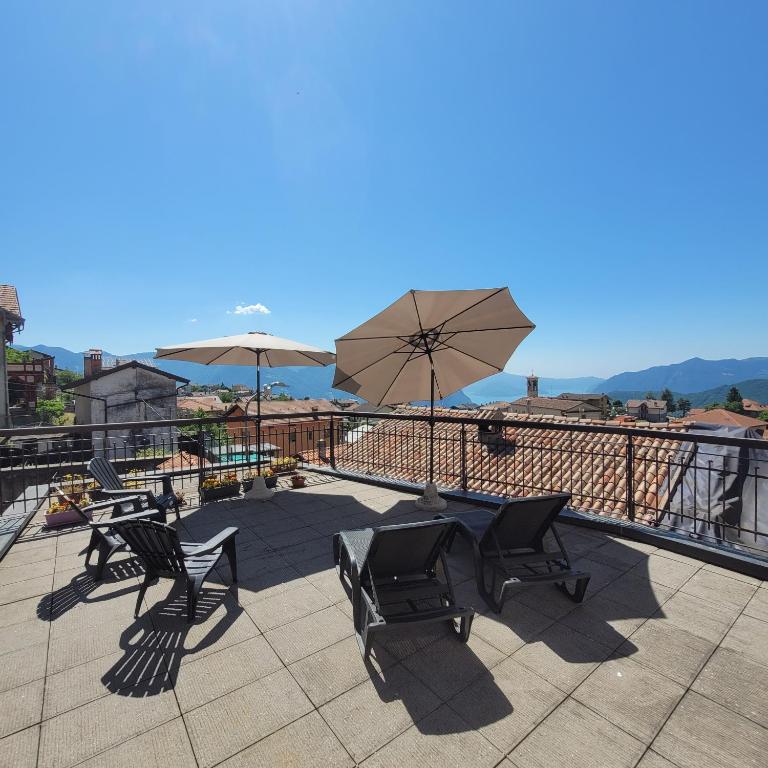 a patio with chairs and tables and umbrellas at Castello Mountain Lake Iseo Hospitaty in Bossico