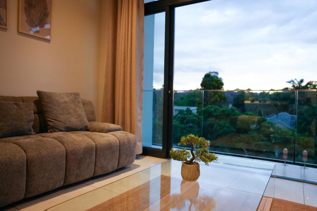 ヨハネスブルグにあるSecure and modern private flat Houghton Estateのソファと大きな窓のあるリビングルーム