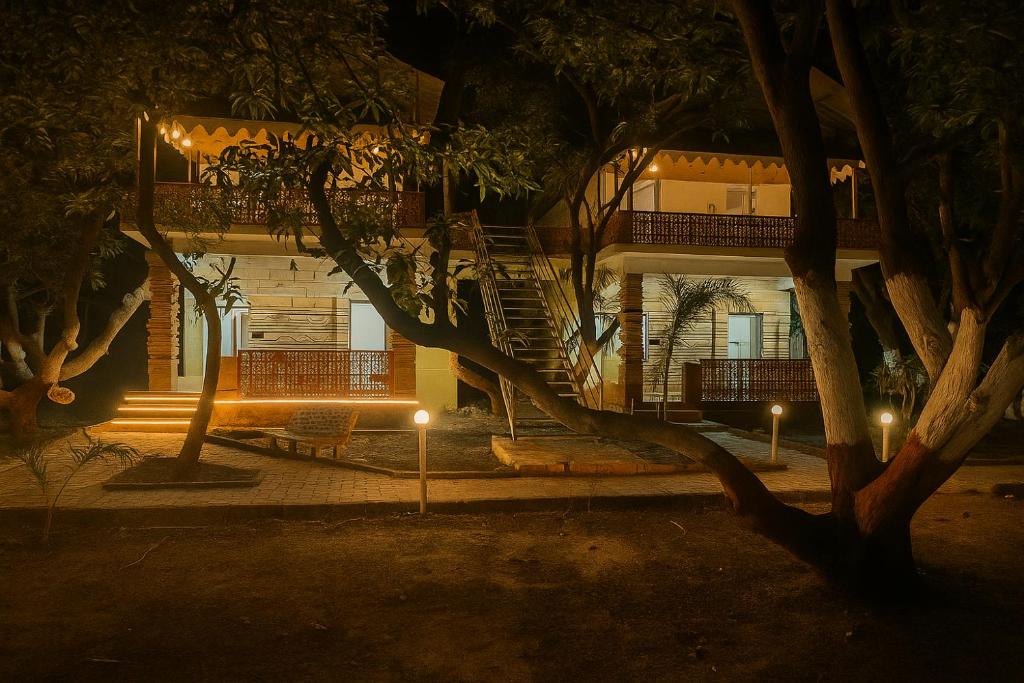 een gebouw met een boom ervoor in de nacht bij The Wilds Villa Gir Jungle Stay with Swimming Pool in Sasan Gir