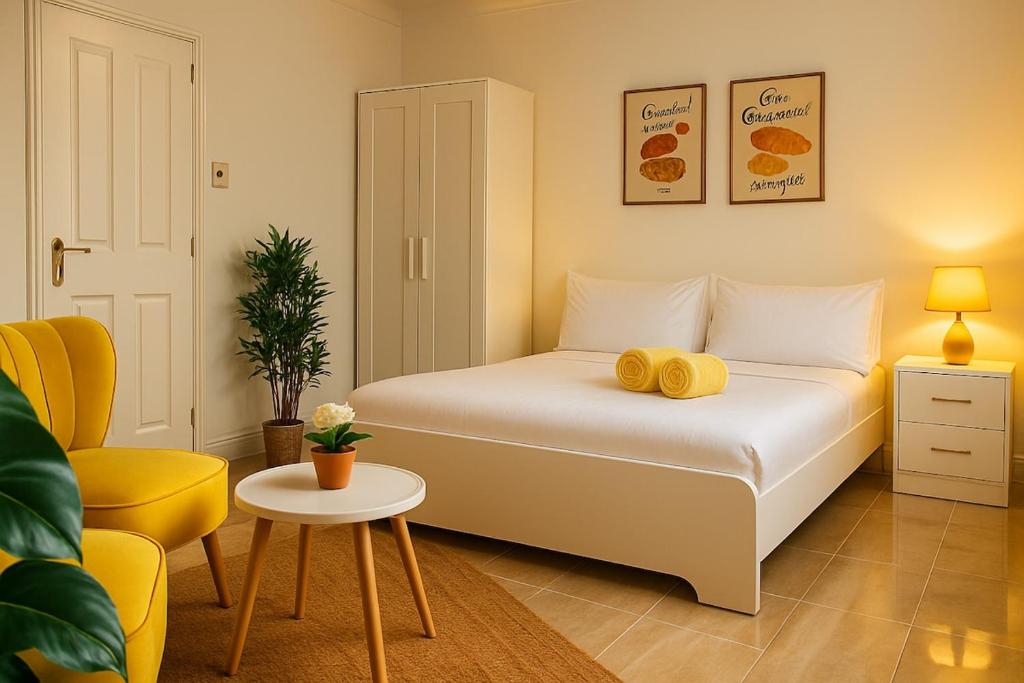 ein Schlafzimmer mit einem Bett mit gelben Kissen darauf in der Unterkunft Boutique-Style Studio Near BHX Airport & NEC in Birmingham