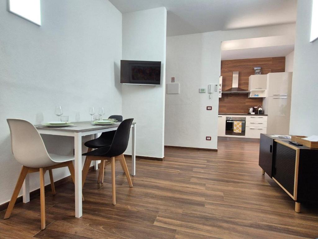 a dining room with a table and chairs and a kitchen at Maison Alice in Alba