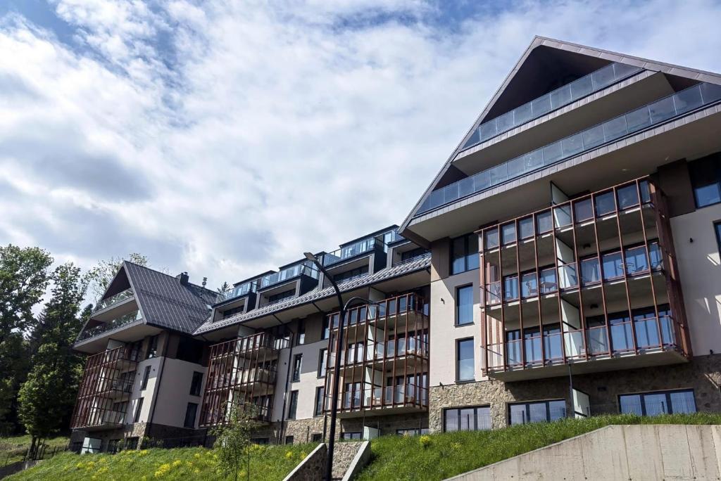 an apartment building with many windows on a hill at Apartament Ski &Sun in Świeradów-Zdrój