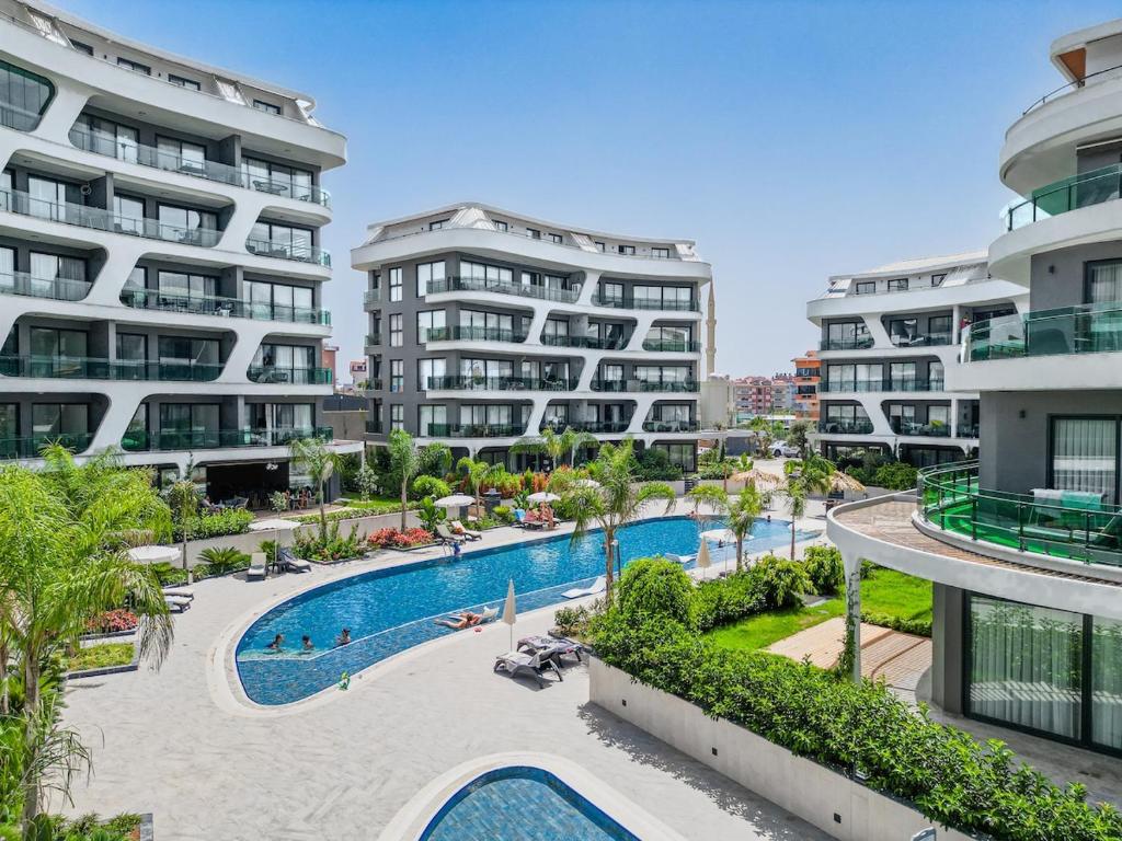 an apartment complex with a swimming pool and two tall buildings at Coastal Retreat with Pool and Balcony in Alanya